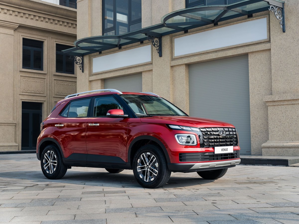 Hyundai Venue màu đỏ đỗ trước tòa nhà