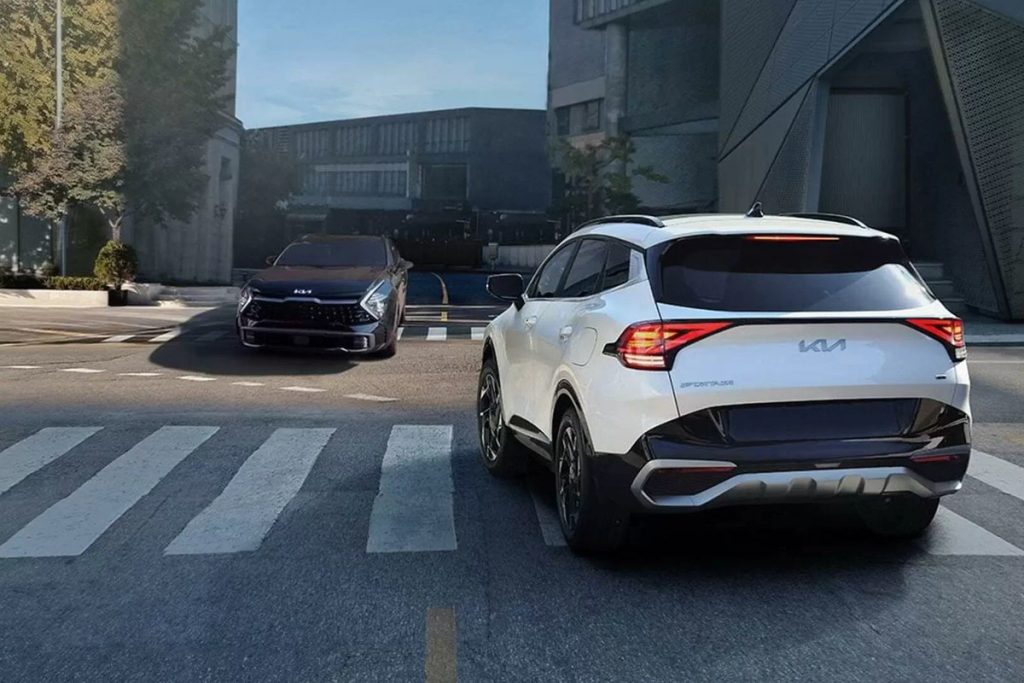 Kia Sportage màu trắng nhìn từ phía sau trên đường