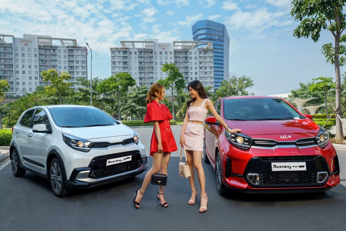 Hai chiếc Kia Morning màu trắng và đỏ đỗ trước tòa nhà