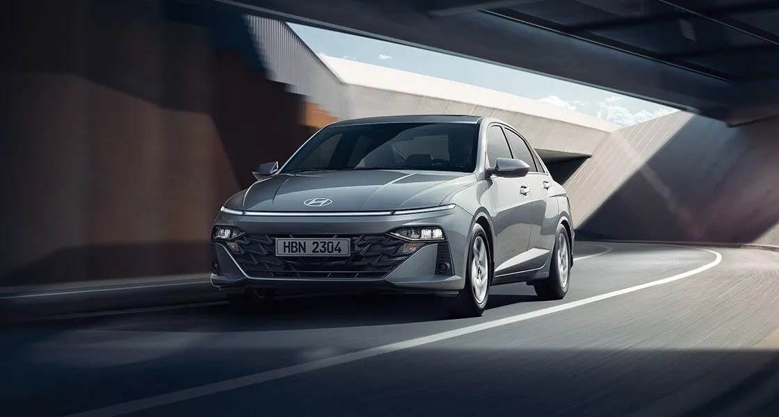 New Hyundai Accent màu bạc vào cua trong không gian kiến trúc hiện đại
